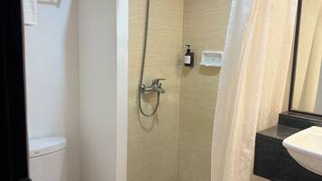 Ein Badezimmer mit Dusche, Toilette und Waschbecken.