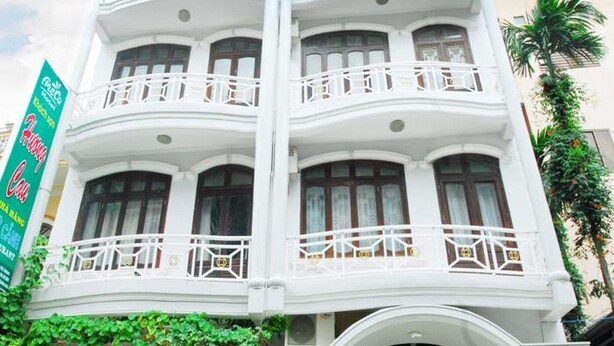 A multi-story building with balconies, a restaurant named "Khoa Son," and a green banner advertising "Famous Cafe." - Areca Hotel (Hue)