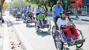 A group of people in wheelchairs on a street. - Areca Hotel (Hue)