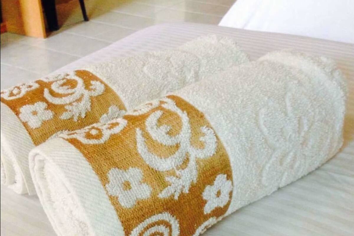 A neatly folded towel with a decorative pattern on a light-colored surface.
