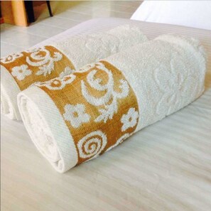 A neatly folded towel with a decorative pattern on a light-colored surface. - Landcons Hotel (Langkawi)