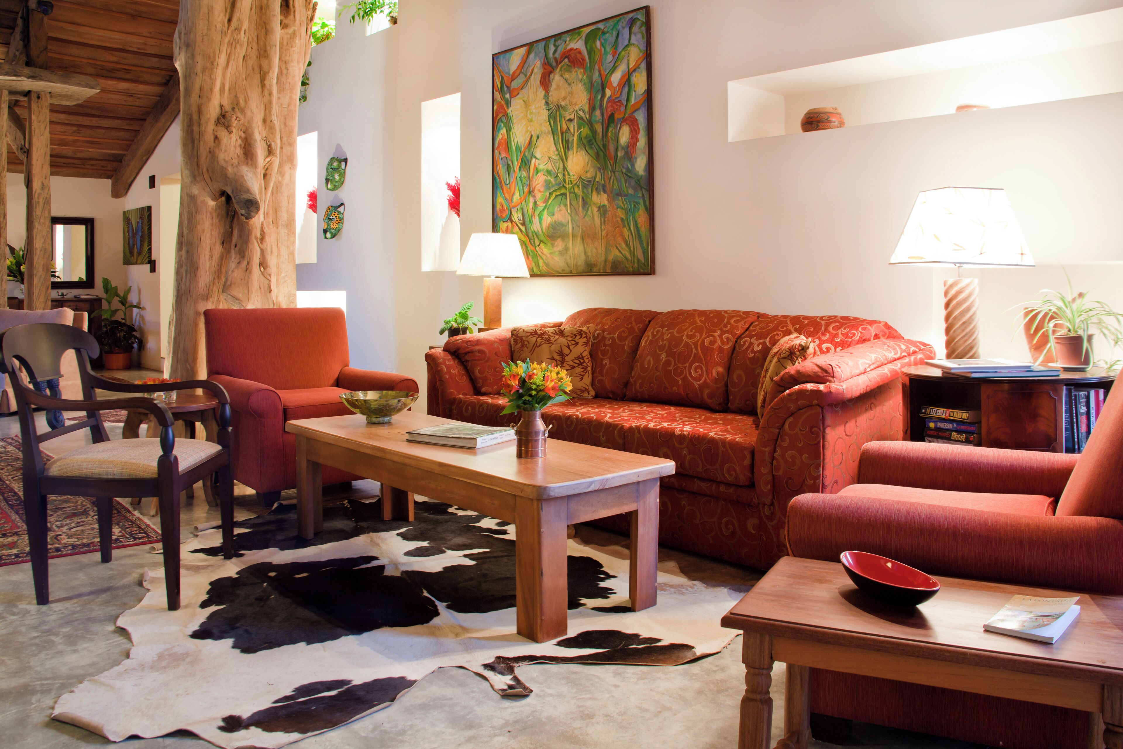 Un salon comprenant un canapé, des fauteuils, une table basse et un tapis.