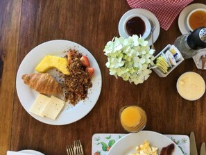 A breakfast setting with croissants, strawberries, and a bowl of cereal on a plate. - Poas Volcano Lodge (Vara Blanca)