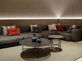A modern living room with a sectional sofa, two side tables, and decorative vases.
