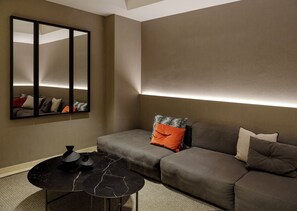 A modern living room with a sofa, a coffee table, and a wall-mounted mirror. - Musik Boutique Hotel - Adults Only (Barcelona)