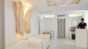 Eine moderne Hotelhalle mit weißem Sofa, Wanddekoration und einer Rezeption.