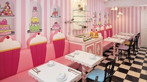 Ein Restaurant mit rosafarbenen und weißen Streifen an den Wänden, einem karierten Boden und rosafarbenen Sitzelementen mit weißen Tischen.