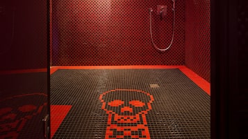 Shower area features a bold checkered tile pattern and a stylized skull design on the floor.
