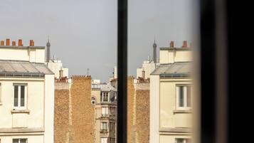 A row of buildings with brick facades and flat roofs, viewed through a window frame.