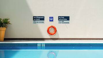 A swimming pool with safety signs indicating no diving and no swimming.