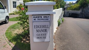 A sign for Edgehill Manor Guest House with a 'Guests Only' and 'No Trespassing' notice. - Edgehill Manor Guest House (Pembroke Parish)