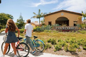 A Courtyard Marriott hotel entrance with a sign, a pathway, and a bicycle.