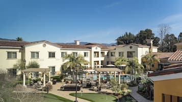 Relax by the pool surrounded by lush greenery and a Mediterranean-style courtyard.