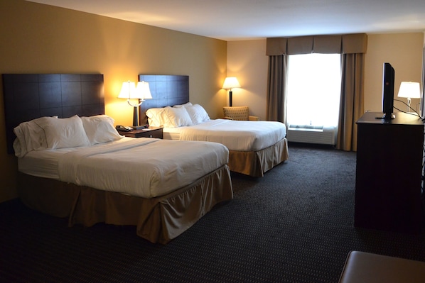 Quarto de hotel com duas camas, uma escrivaninha, uma cadeira e uma televisão.