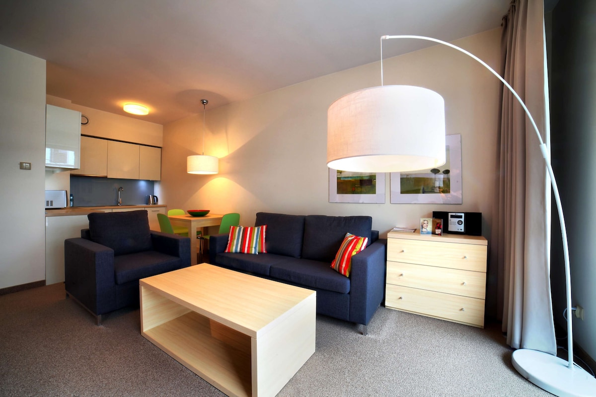 Ein modernes Wohnzimmer mit einer Couch, einem Couchtisch und einem Essbereich mit Stühlen.