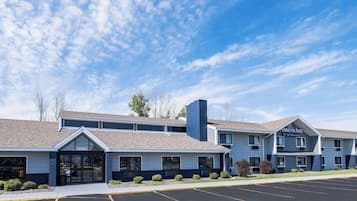 A two-story hotel with a 'Lobby' entrance, a parking lot, and a clear blue sky.