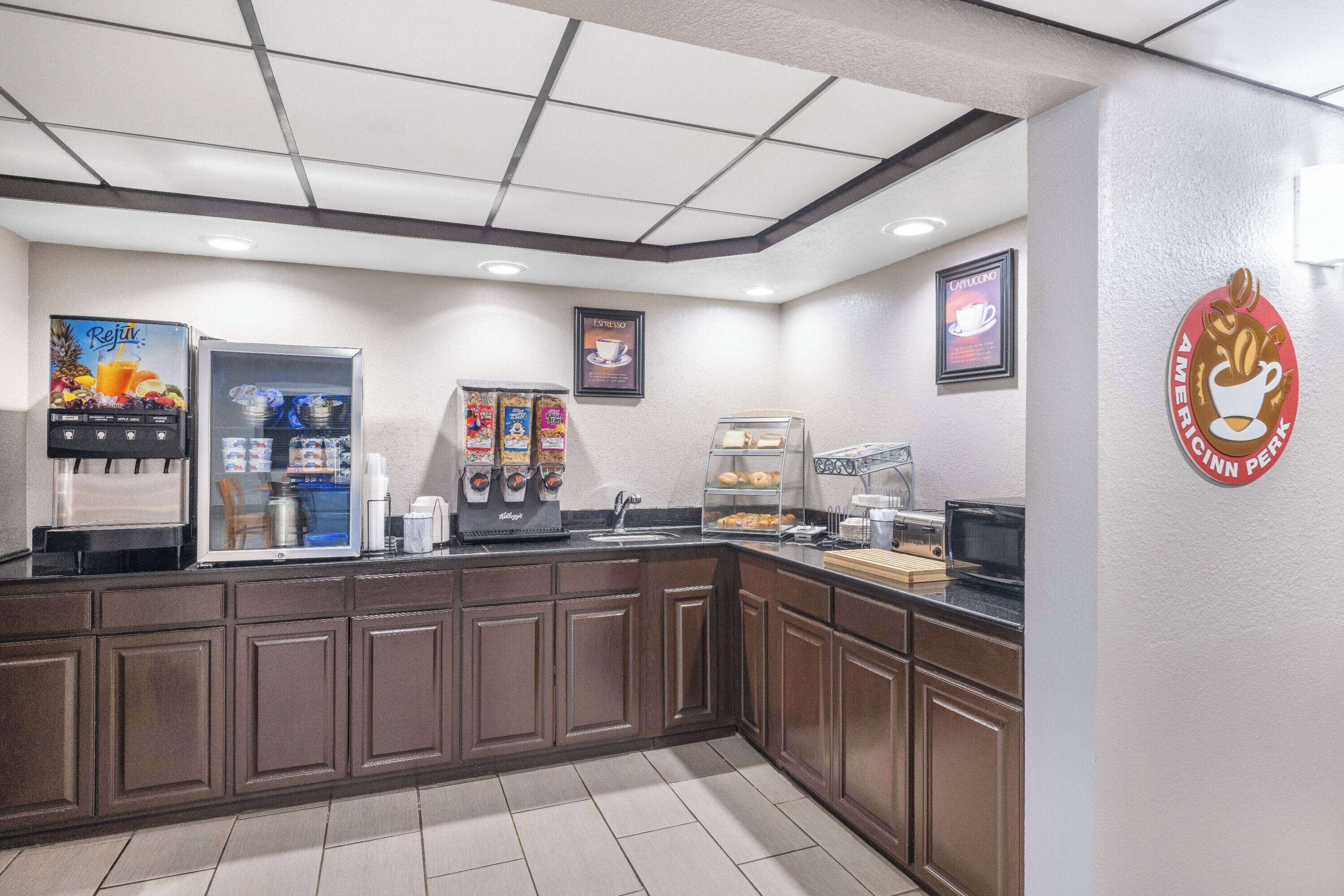 A commercial kitchen with a coffee station, including a coffee machine, espresso machine, and a display of coffee products.