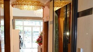 A hotel lobby with a polished floor, a reception desk, and a large chandelier. - Green Centre Point Inn (Phnom Penh)