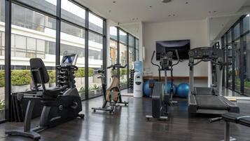 A gym with cardio machines, a treadmill, and exercise balls.