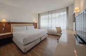 A hotel room with a large bed, a desk, a chair, and a TV. - Hotel Chico Parque 93 By OxoHotel (Bogotá)