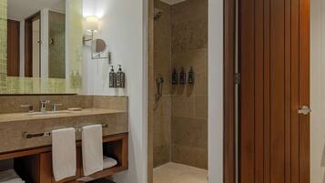 Un baño moderno con un espejo grande, lavamanos dobles y zona de ducha.