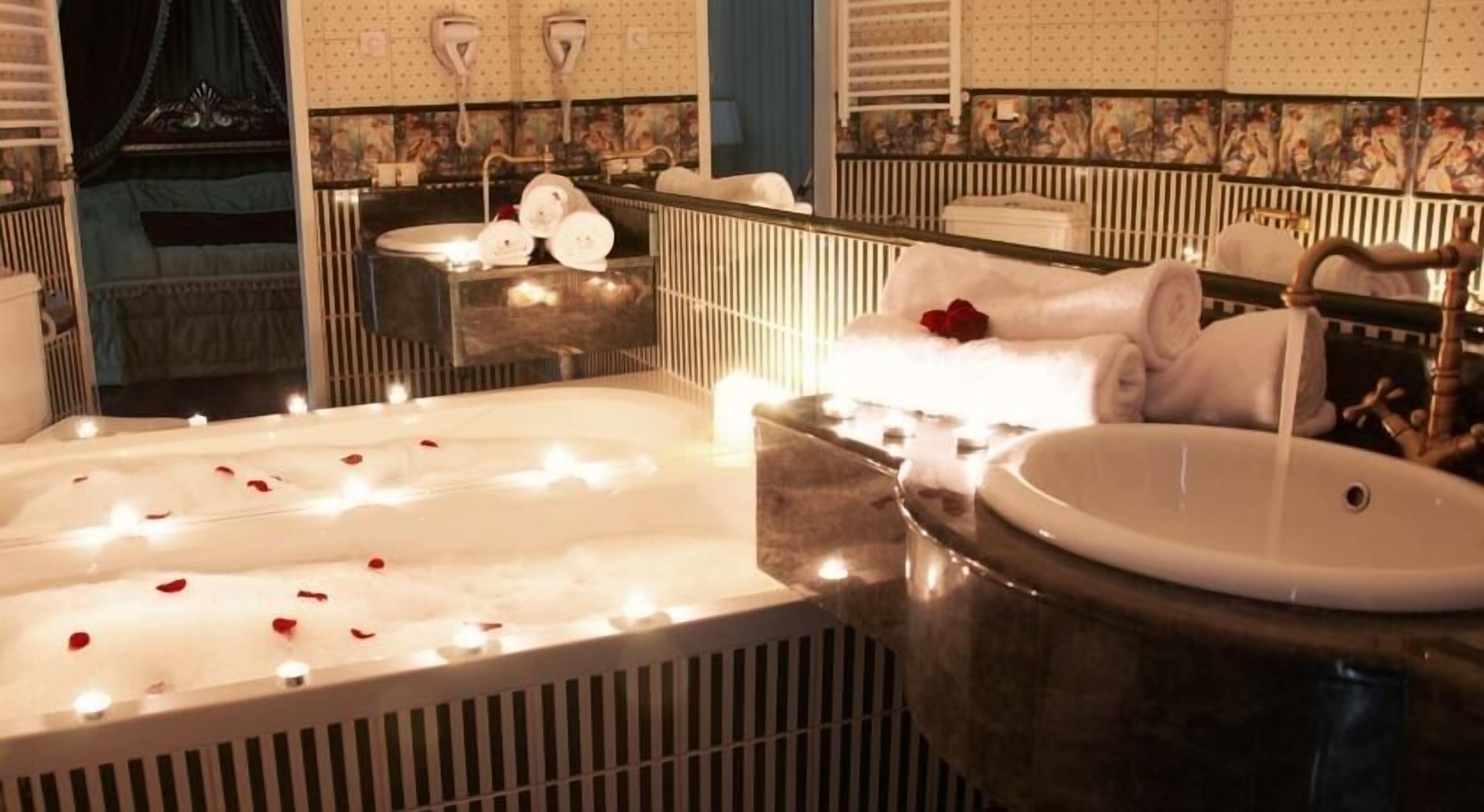 Une salle de bain avec une grande baignoire, un lavabo rond et un miroir.