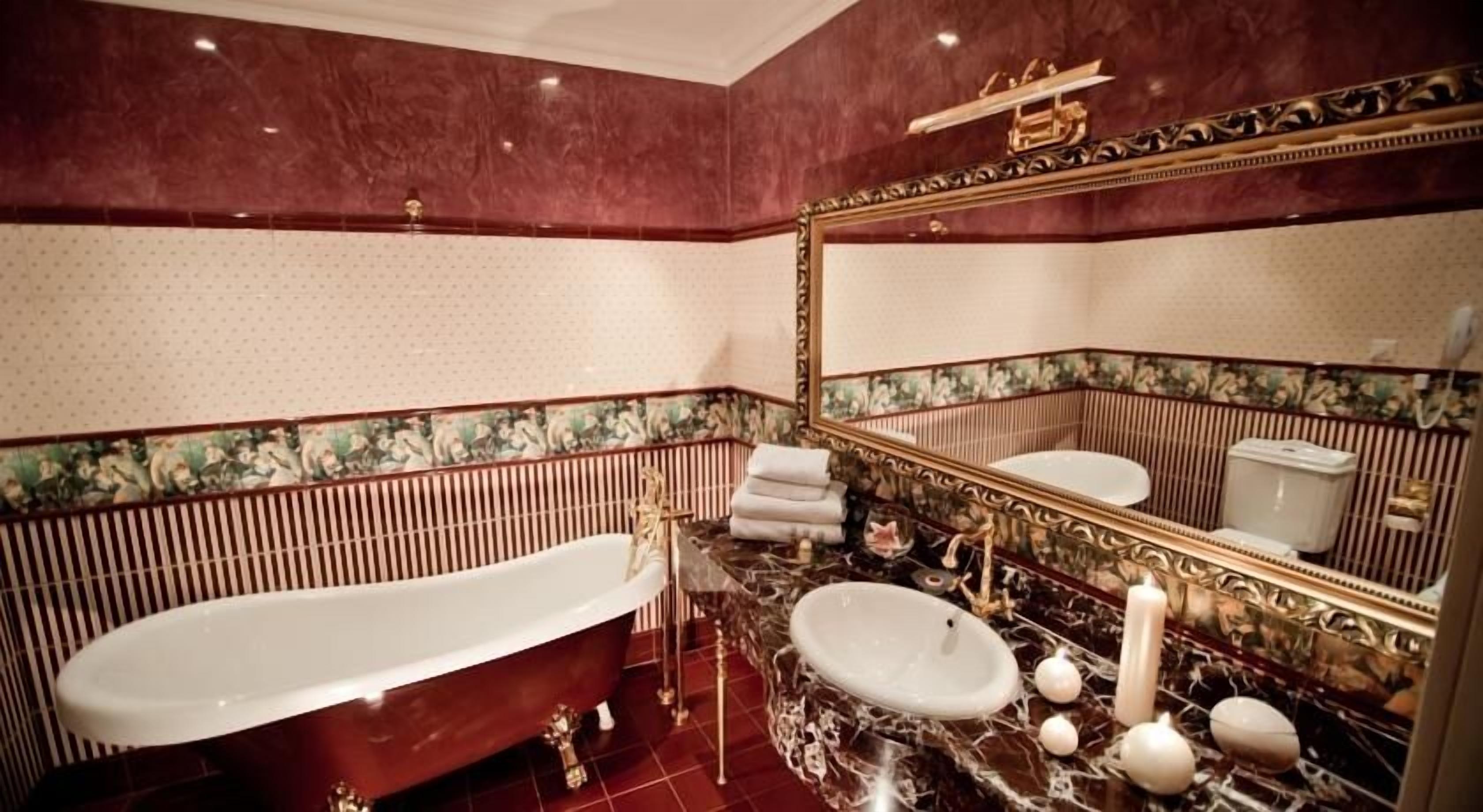 A bathroom with a freestanding bathtub, a marble sink, and a toilet.