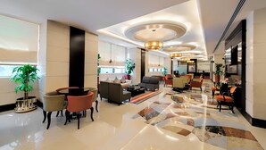 A spacious lobby with a polished floor, comfortable seating areas, and modern lighting fixtures.