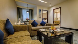 A living room with two sofas, a coffee table, and a dining area with a table and chairs.