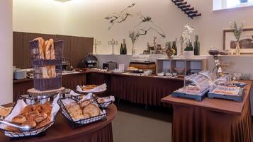 A buffet setup with various food items and a wine rack on the wall.