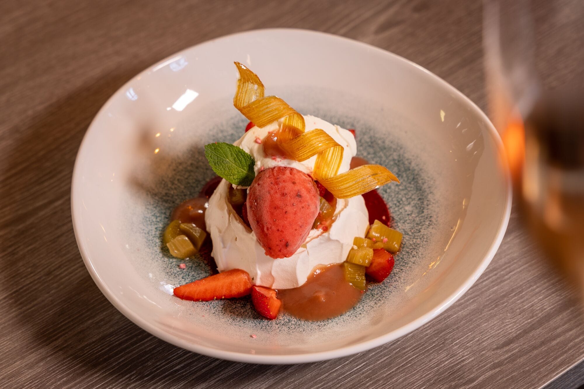 A dessert on a ceramic plate with a wooden table background.