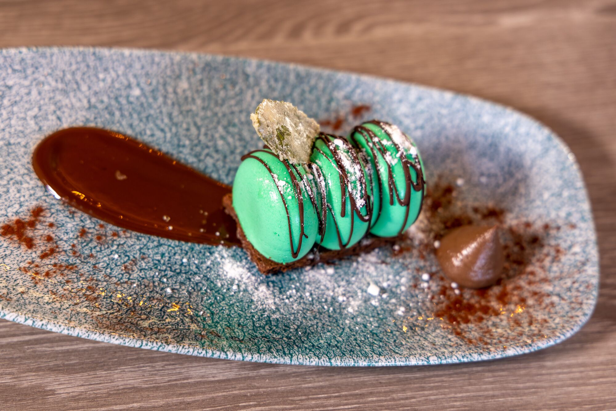 A dessert on a plate with a chocolate sauce and powdered sugar.