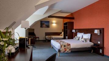 Une chambre d’hôtel avec un lit, un bureau, une chaise, une lampe et un tableau au mur.