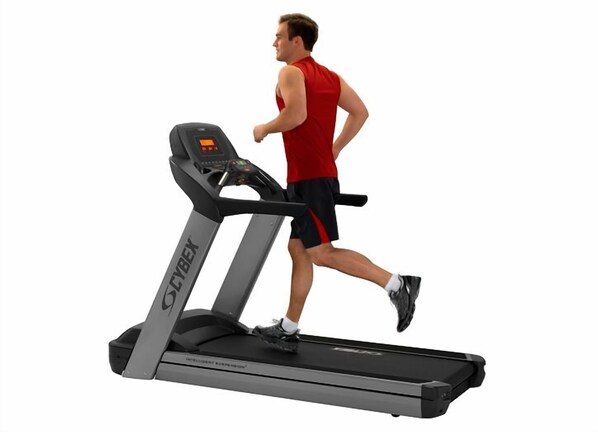 A treadmill with a digital display and a user running on it.