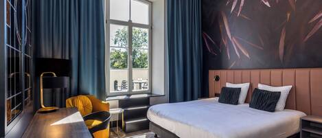 Un dormitorio moderno con una cama grande, un escritorio, una silla y un ventanal con cortinas.