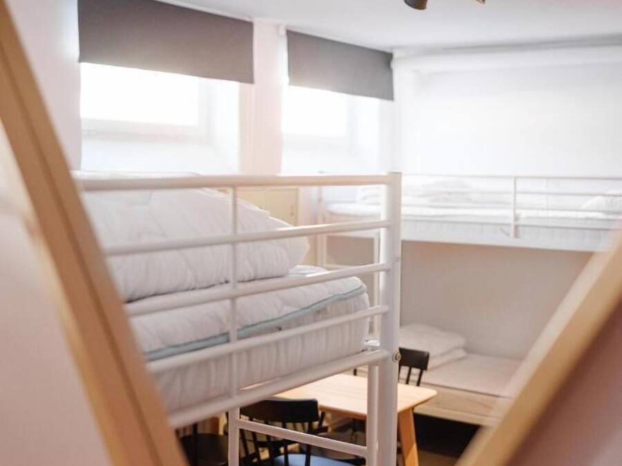 Ein Schlafsaalzimmer mit Etagenbetten, einem Schreibtisch und einem Stuhl.
