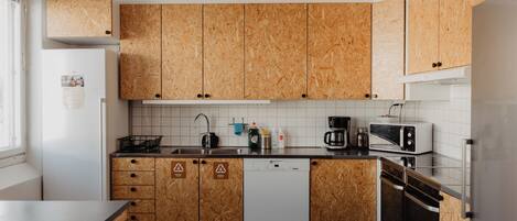 Una cocina moderna con armarios de madera, lavavajillas, cafetera y microondas.