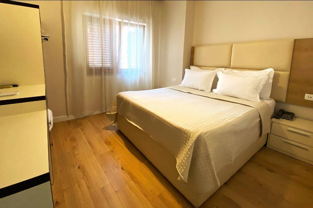 Una habitación de hotel con cama, mesita de noche y escritorio con silla.