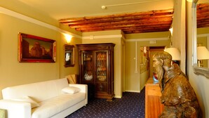 A room with a white sofa, a wooden statue, and a patterned carpet. - Ca' Pedrocchi (Venice)