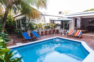 Una piscina al aire libre, sombrillas