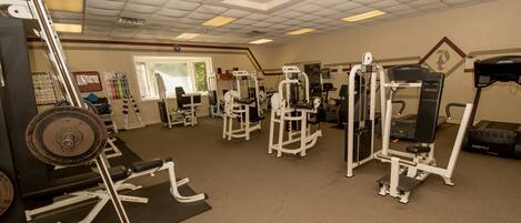 A gym with various exercise equipment, including weight machines and cardio machines.
