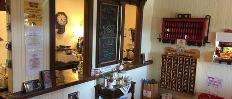A cozy bar area with a wooden counter, a chalkboard menu, and a variety of bottles and glasses.