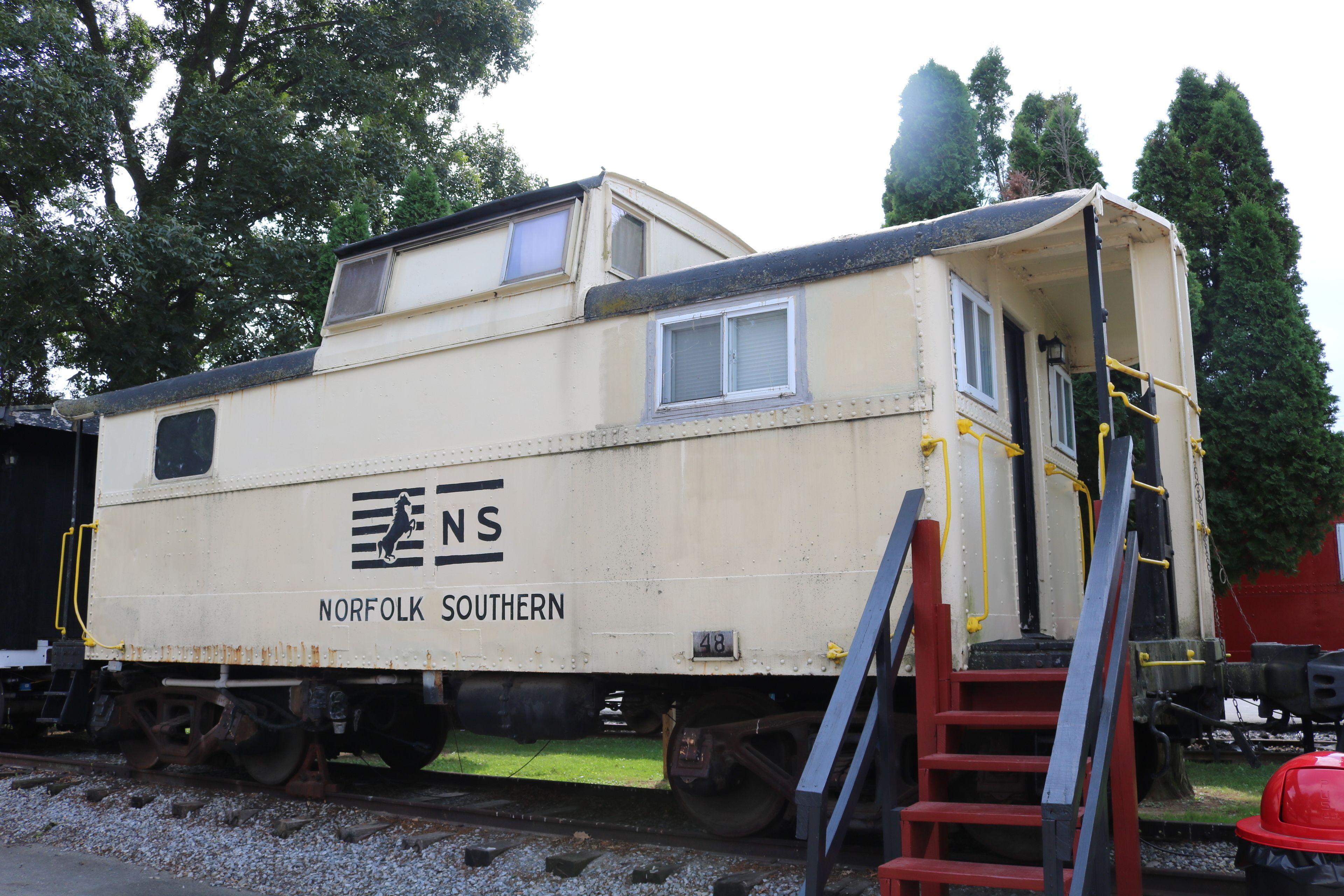 Un wagon de queue de la compagnie Norfolk Southern, doté d’une petite cabine, d’une échelle et d’une plateforme.