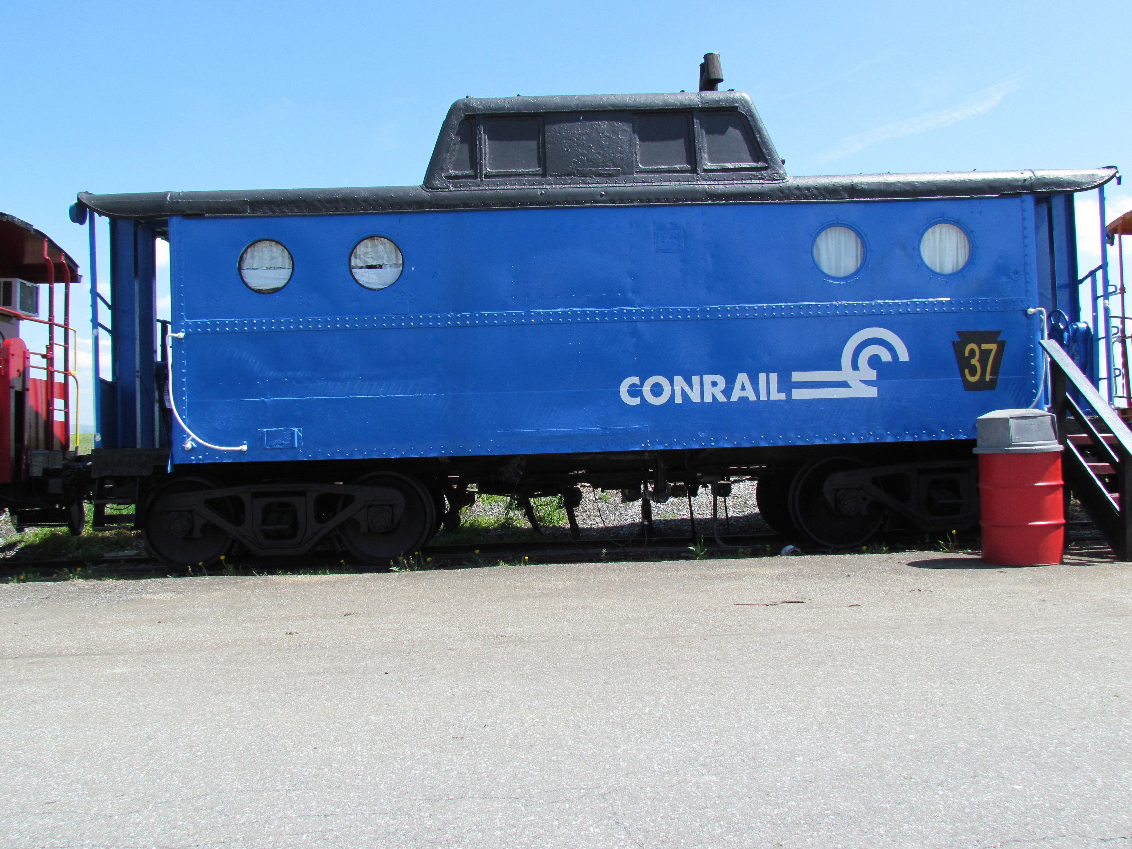 A blue train car with the number 37 and the word "CONRAIL" on it.