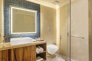 A bathroom with a large mirror, a white sink, a shower, and a toilet. - Sterling Amargarh Jodhpur (Luni)