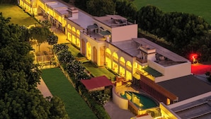A large, multi-story hotel with a swimming pool and solar panels. - Sterling Amargarh Jodhpur (Luni)