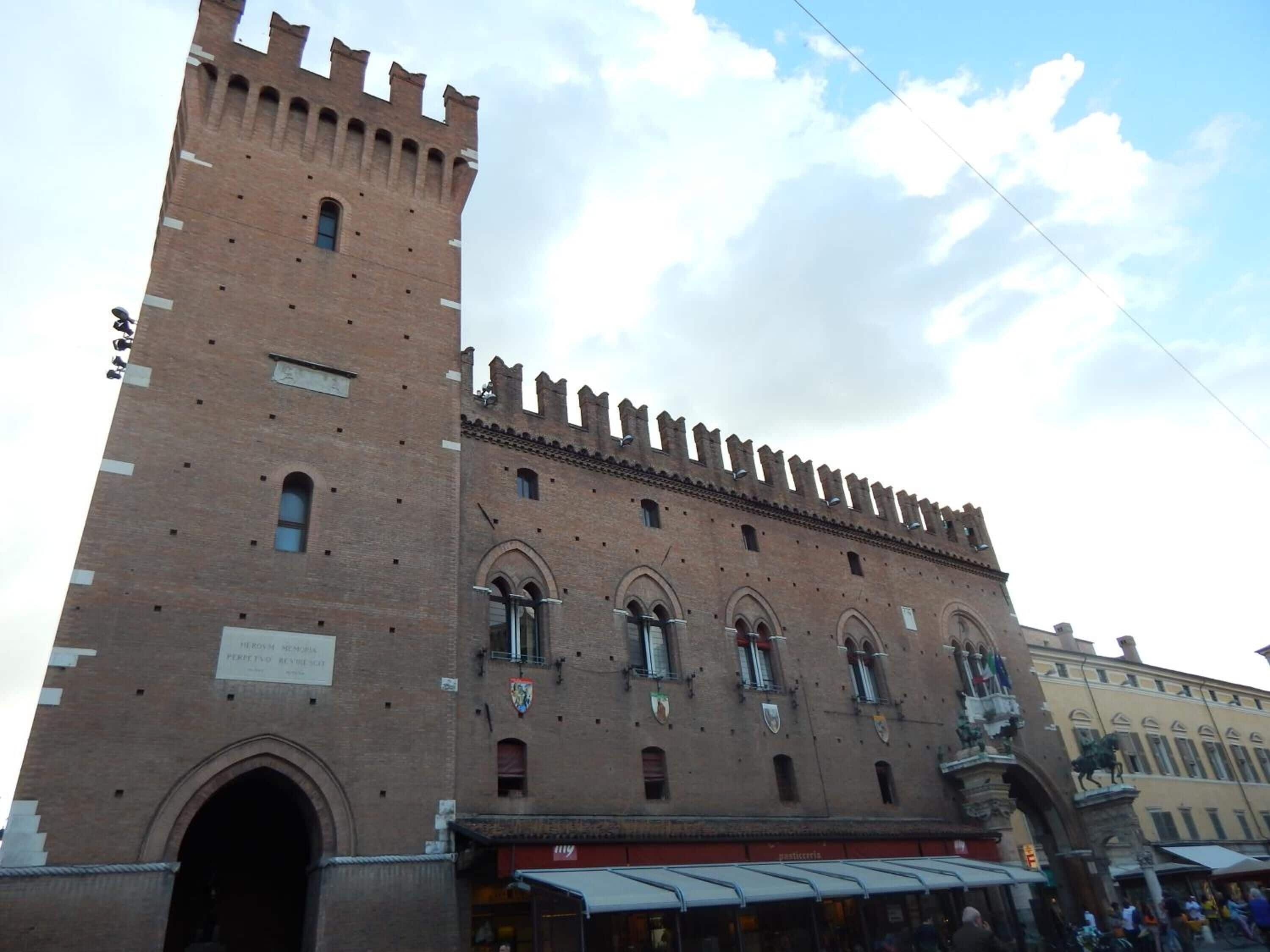 Un edificio histórico con una torre alta y ventanas de arco.