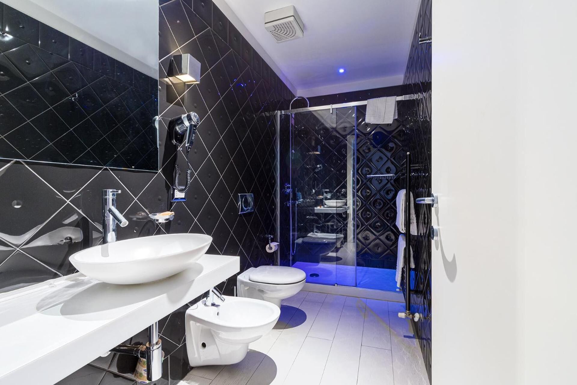 Ein modernes Badezimmer mit einem großen weißen Waschbecken, einem Bidet und einer Toilette.