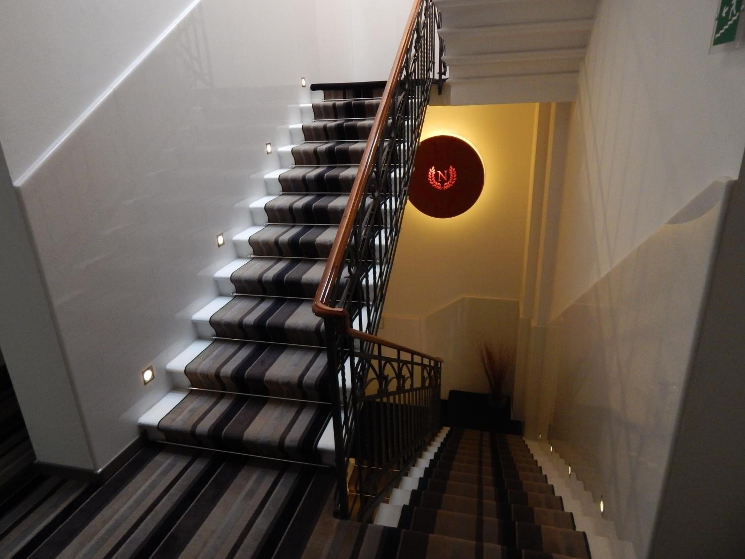 Een trap met een gestreept tapijt en een rood rond bord.