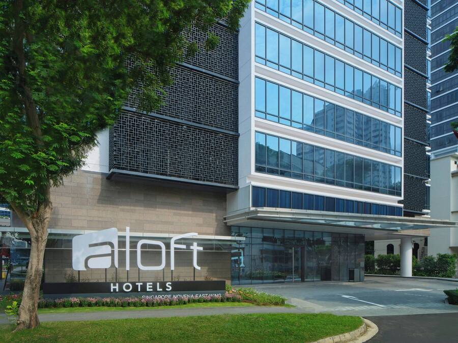 A modern hotel building with a prominent sign reading "Alloft Hotels".
